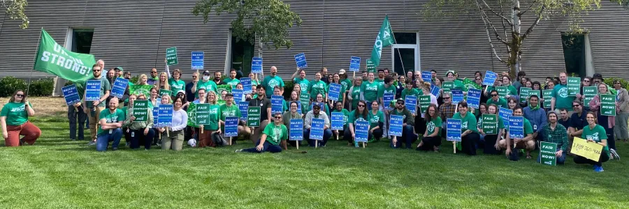 Photo of many Local 872 members in green shirts holding rally signs
