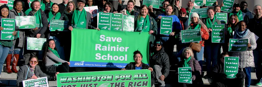 Several people in AFSCME green and holding signs that say "Save Yakima Valley School"