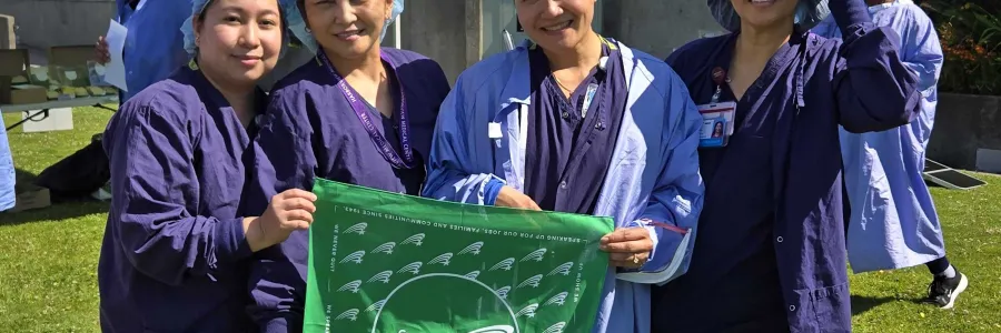 UW Members at Harborview hold up a WFSE bandana in their scrubs