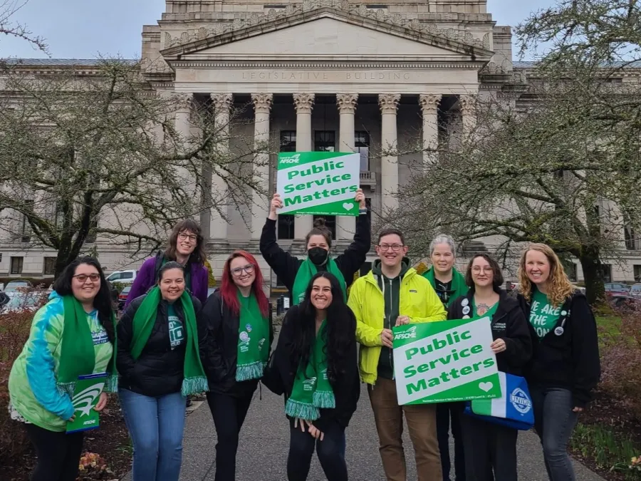 WFSE members holding signs that say "Public Service Matters" and standing in front of the state capitol building