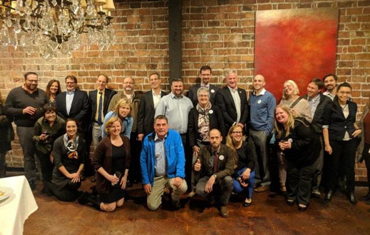 A group of the Washington Association of Assistant Attorneys General (AWAAG) members and WFSE staff poses in front of a brick wall.