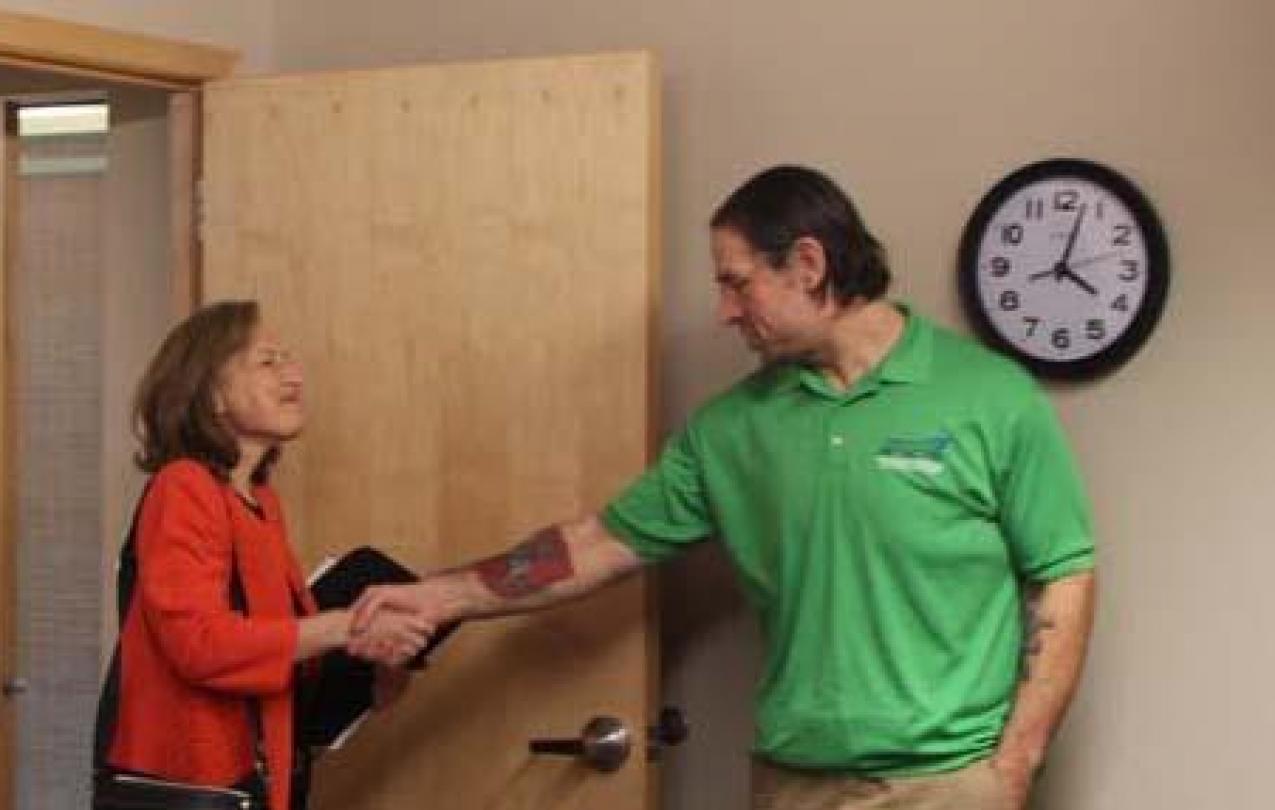 Congressperson Kim Schrier enters a door and shakes hands with WFSE President Mike Yestramski
