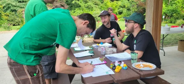 Photo of person in a green shirt filling out a form at an event.
