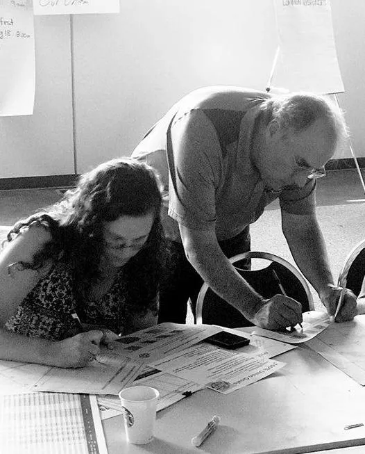 Two people signing union cards over a table.