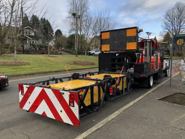 Photo shows rear view of a construction truck with a truck mounted attenuator