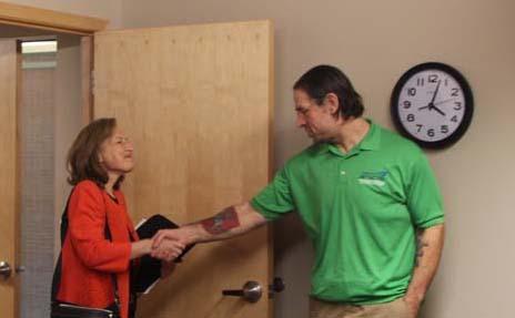 Congressperson Kim Schrier enters a door and shakes hands with WFSE President Mike Yestramski